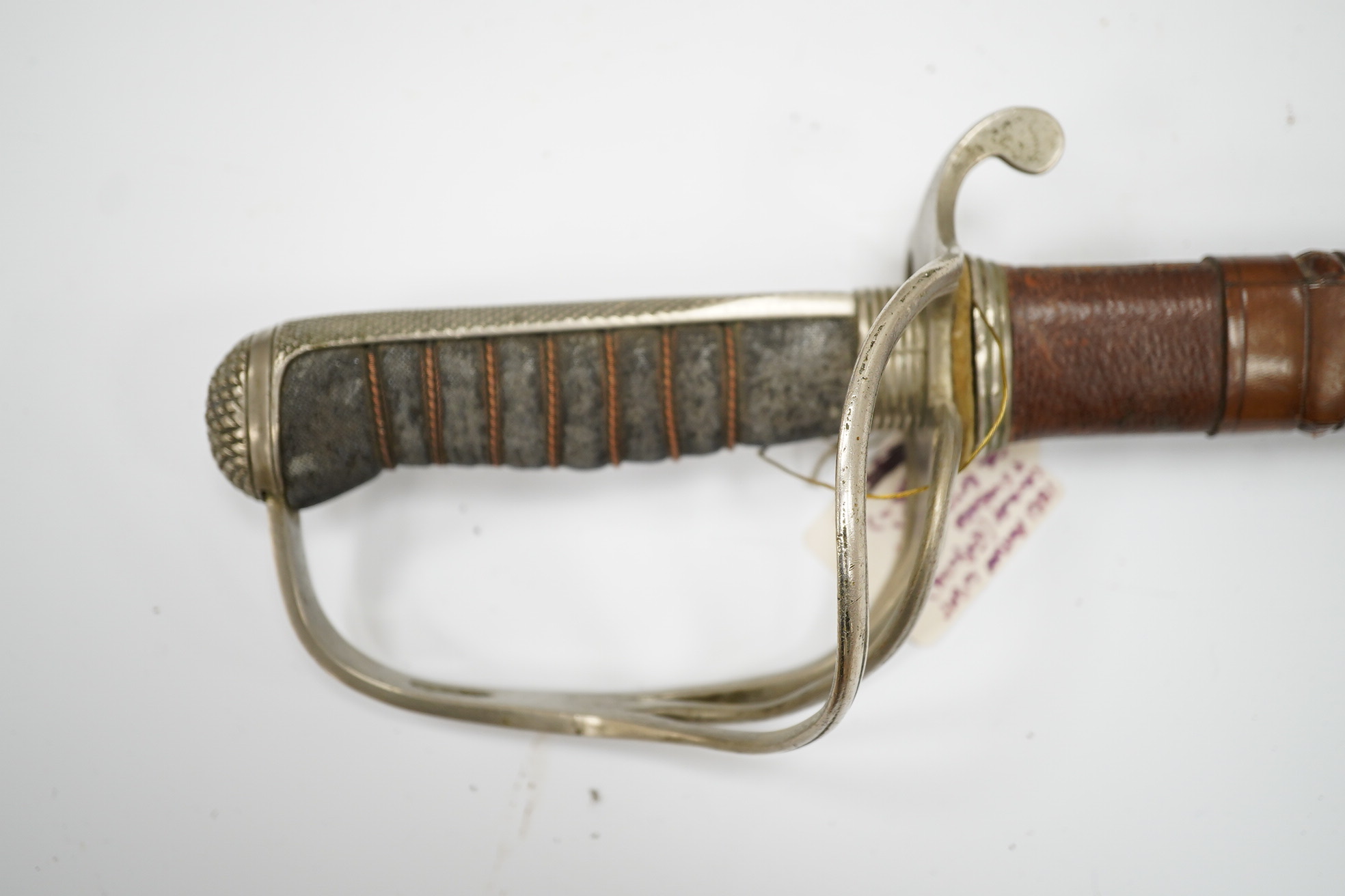 An 1821 pattern GVIR light cavalry officer’s sword in its leather scabbard, Royal Army Service Corps, blade etched with owners initials; JNDA and also with initials RASC, with regulation nickel guard, in its leather fiel